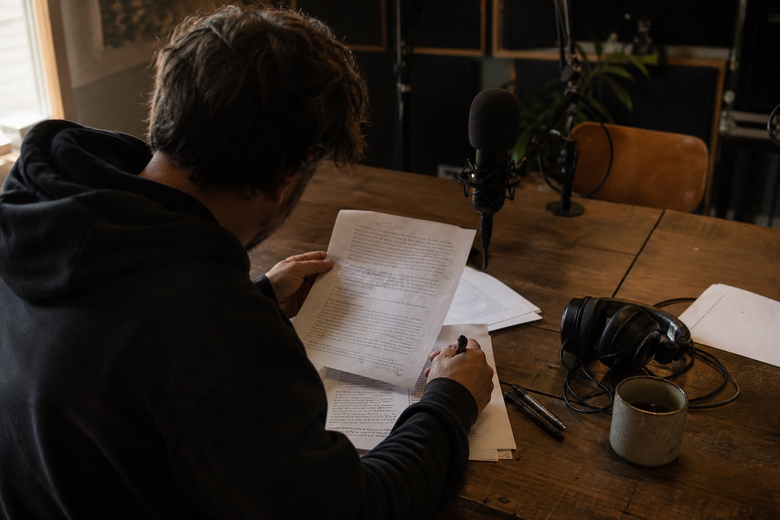Un créateur relit la transcription d’un épisode dans un studio de podcast