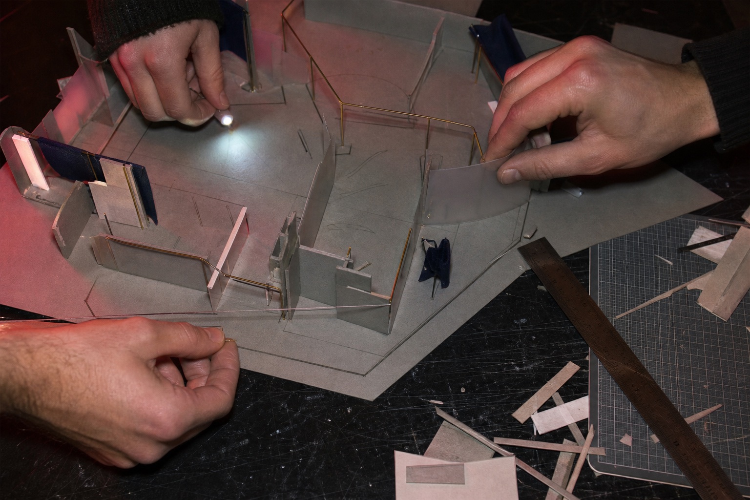 Les mains de l’équipe déplacent les volumes d’une maquette physique